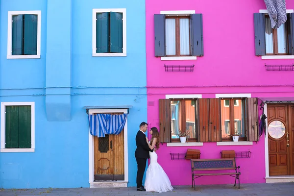 Sposo e sposa di fronte a una casa blu e viola — Foto Stock