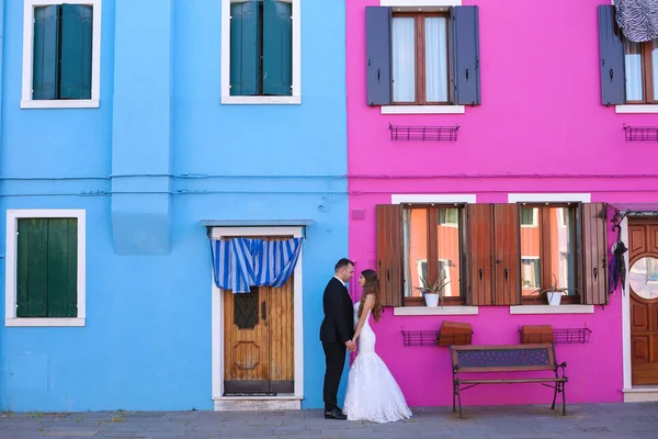 Bräutigam und Braut vor einem blau-lila Haus — Stockfoto