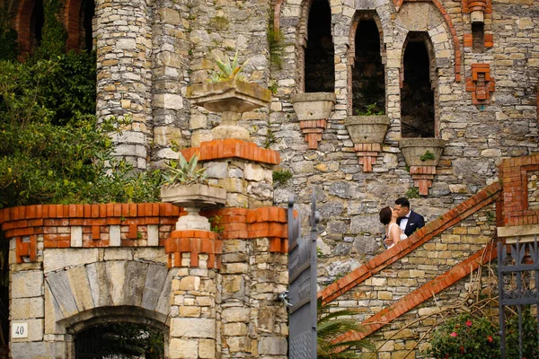 Жених и невеста целуются на лестнице замка — стоковое фото