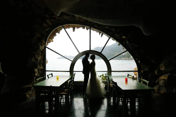 Bräutigam und Braut Silhouette in der Nähe eines Fensters zum Meer — Stockfoto