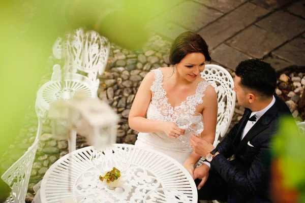 Nevěsta a ženich sedí u stolu — Stock fotografie