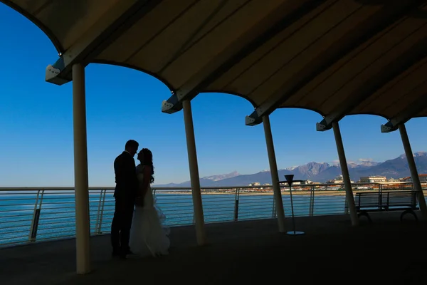 一对新婚夫妇在海边接吻的剪影 — 图库照片