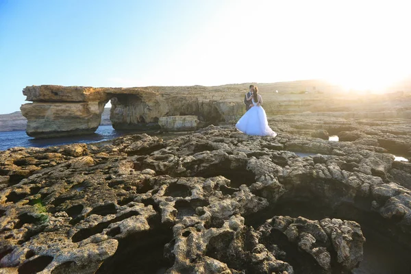 Novio y novia en las rocas cerca del mar — Foto de Stock