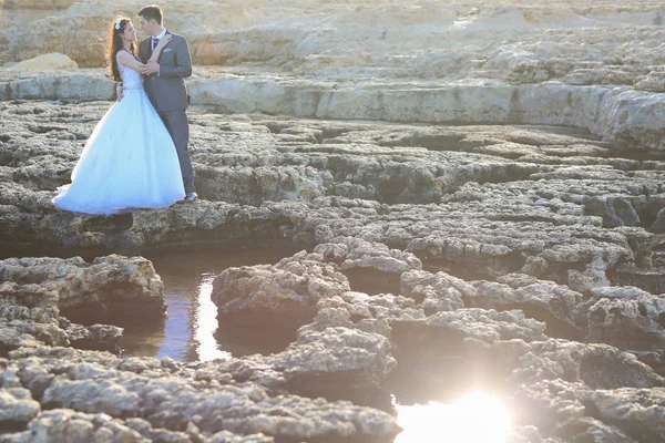 Groom and bride on the rocks near the sea — Stock Photo, Image