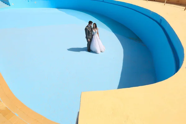신랑과 신부는 빈 수영장에서 — 스톡 사진