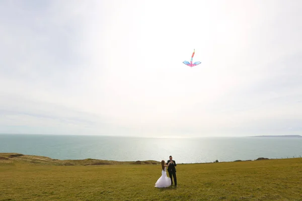 Novia y novio divirtiéndose con una cometa —  Fotos de Stock