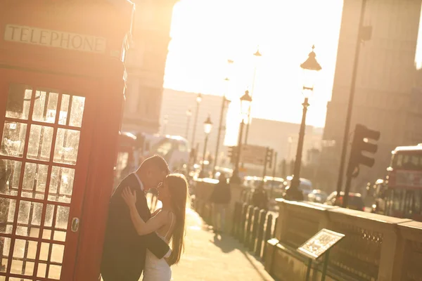 Ženich a nevěsta poblíž telefonní kabiny v Londýně — Stock fotografie