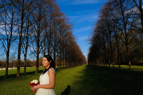 公園で彼女の結婚式のブーケを持つ花嫁 — ストック写真