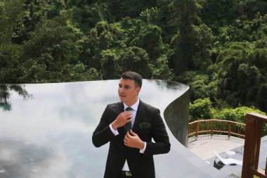 Bir tropik tatil havuz kenarında yakışıklı damat