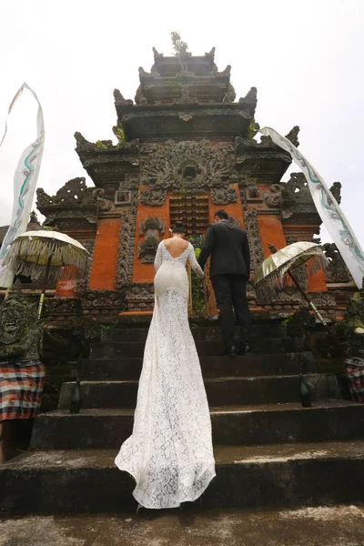Жених и невеста возле храма в Азии — стоковое фото