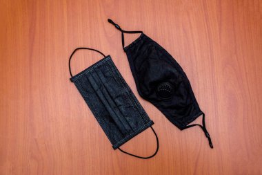 Siyah tıbbi yüz koruyucu maskeler ahşap arka planda.