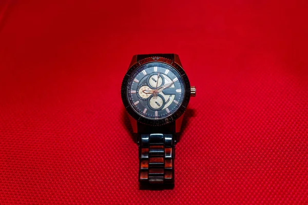 美しい男性の手首金属腕時計に対する赤い服の背景 — ストック写真