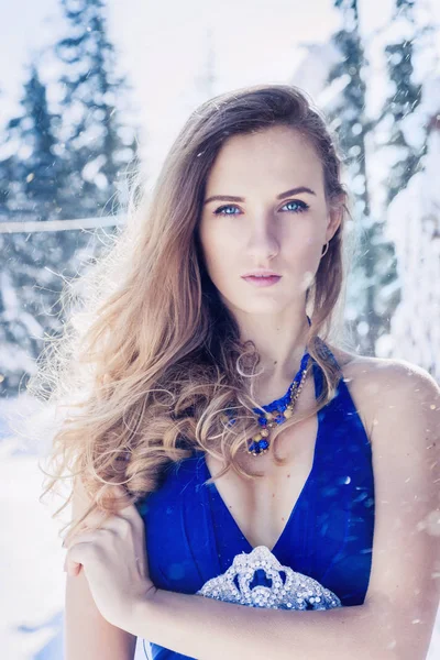 Karlı dağlarda bir arka plan üzerinde güzel elbiseli genç kız portresi