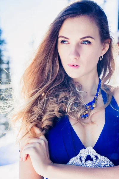 Karlı dağlarda bir arka plan üzerinde güzel elbiseli genç kız portresi