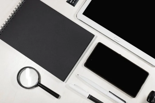 düzgünce katlanmış çapraz olarak siyah beyaz office öğeleri. Beyaz tablet ve kopya alanı ile siyah notebook