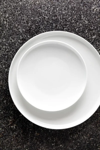 Set of two Porcelain Plates on a black Marble table. Empty space — Stock Photo, Image