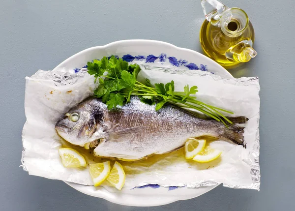 Варена риба, лимон і свіжа петрушка. на сірому столі — стокове фото