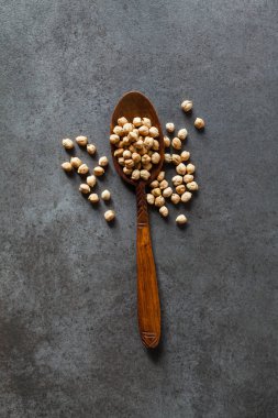 Karanlık bir arka plan üzerine bir tahta kaşık nohut