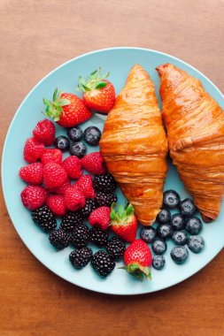 Yaz kahvaltı mavi tabakta. Taze olgun çilek ve pastrie