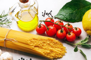 Spagetti makarna üzerine beyaz bir backgrou yemek pişirmek için malzemelerle