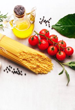 Spagetti makarna üzerine beyaz bir backgrou yemek pişirmek için malzemelerle