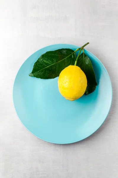 Fresh big natural lemon with leaves on a plate — Stock Photo, Image