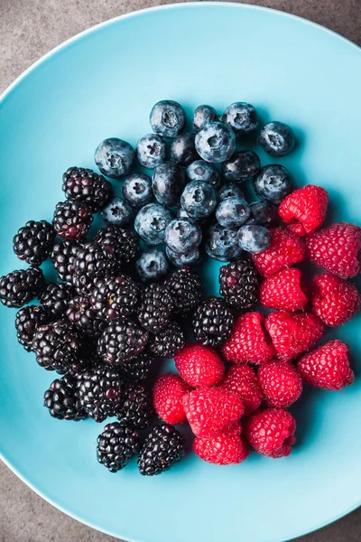 Various fresh summer berries. in blue plate . Top view — Stock Photo, Image