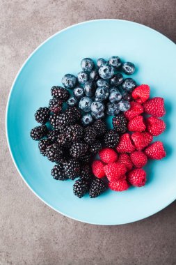 Çeşitli taze yaz meyveleri. Mavi tabak içinde. Üstten Görünüm 