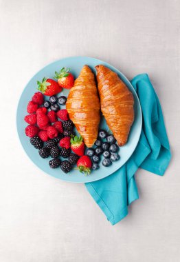 Yaz kahvaltı mavi tabakta. Taze olgun çilek ve pastrie