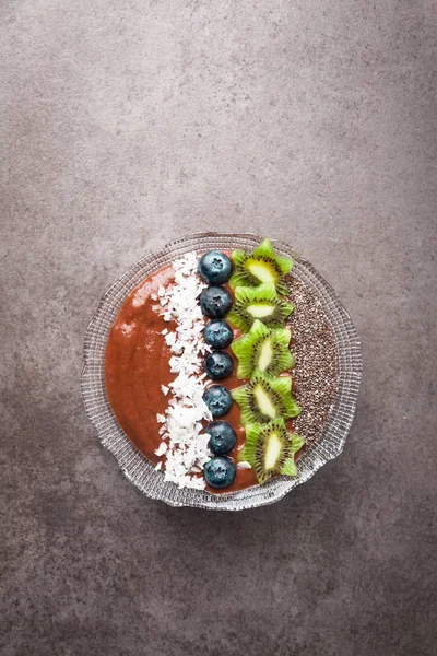 Breakfast berry smoothie bowl topped with blueberries, kiwi, chi