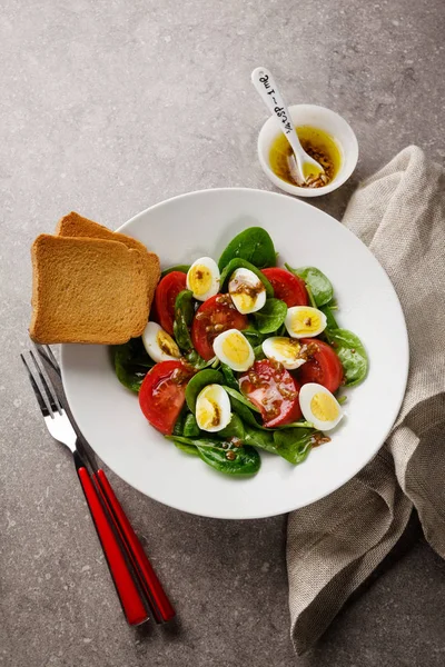 Easter Spring salad with quail eggs, tomatoes and spinach. on th — Stock Photo, Image