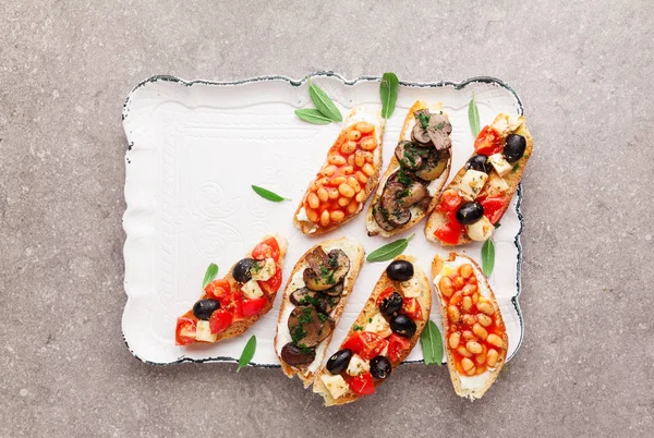 Scala aan kleine bruschetta met caprese salade, witte bonen op — Stockfoto