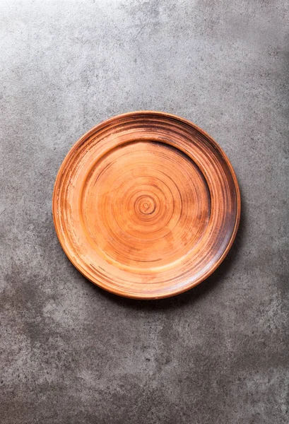 Empty earthenware dish on a dark vintage background. Place for w — Stock Photo, Image