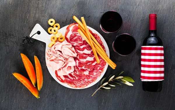 Cold meat cut from different varieties of salami on a dark backg — Stock Photo, Image