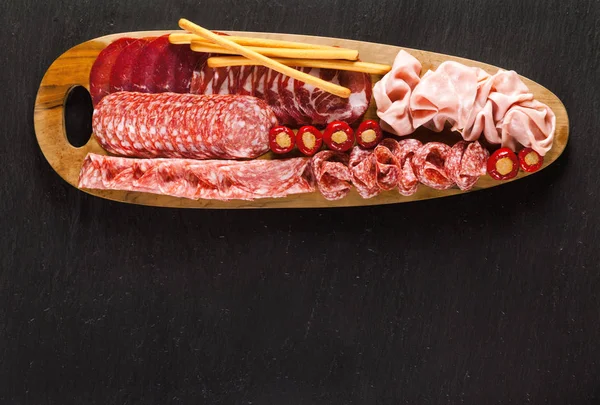 Şarküteri aperatifler sunan bir ahşap tahta üzerinde. Sosis w üzerinde