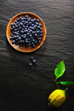 Yaban mersini bir siyah taş zemin ve l bir tabakta yığını