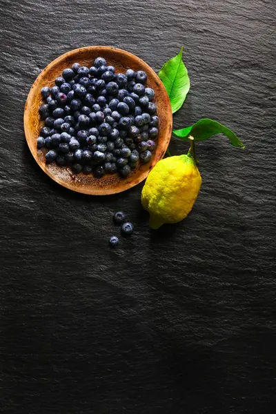 Yaban mersini bir siyah taş zemin ve l bir tabakta yığını