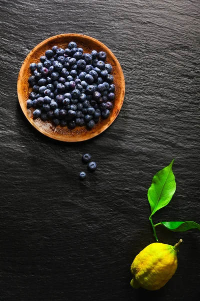 Yaban mersini bir siyah taş zemin ve l bir tabakta yığını