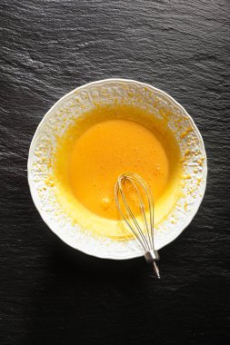 Beyaz bir kase ve bir elektrik karışımı bir üstten çırpılmış yumurta sarısı