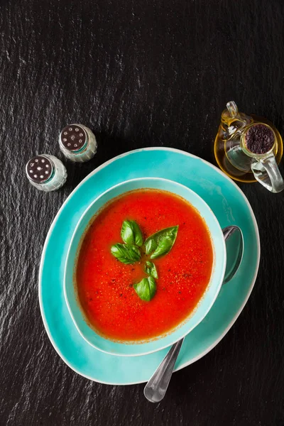 Traditionella kräm av tomatsoppa med basilika på svart sten backg — Stockfoto