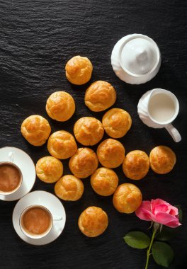 Profiterol ve kahve siyah taş zemin üzerine