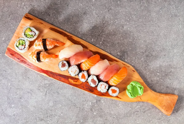 Sushi-Set Sashimi und Sushi-Rollen auf Steinschiefer serviert — Stockfoto