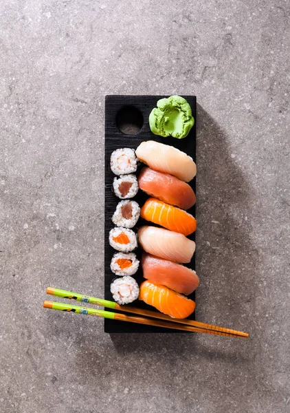 Sushi Set sashimi och sushi rullar serveras på stenskiffer — Stockfoto