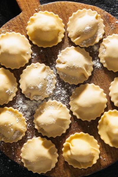 siyah taş zemin ahşap bir gemide pişmemiş mantı.