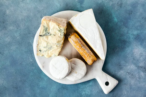 Diferentes tipos de queso italiano en un jabalí de corte de mármol blanco — Foto de Stock