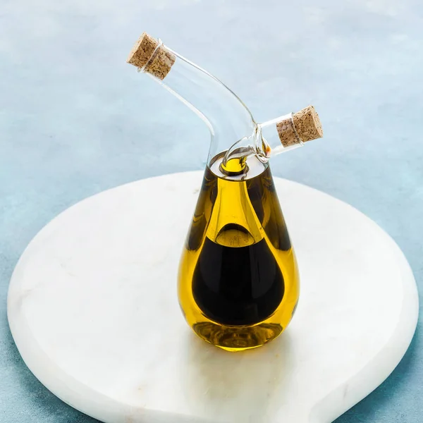 Cruet with olive oil and balsamic vinegar on a blue board — Stock Photo, Image