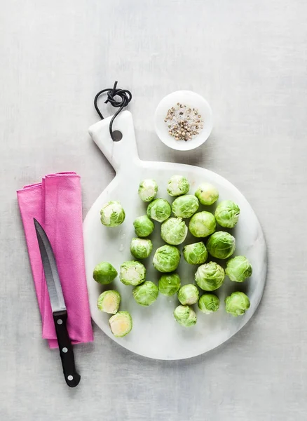 Brussels sprout on a white marble cutting board and knife. spice — Stock Photo, Image