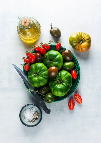 Verschiedene Tomaten auf einem Teller auf einem Tisch aus weißem Stein. f — Stockfoto