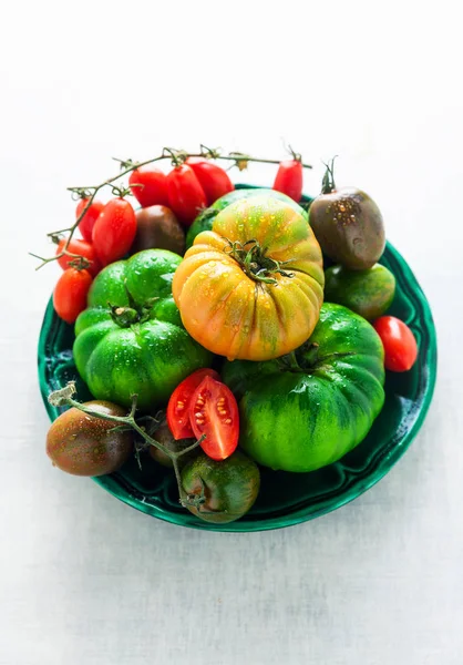Verschiedene Arten, Arten und Farben von Tomaten auf weißem Stein — Stockfoto