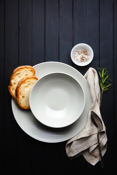 Som serverar soppa. Tomma tallrikar och bröd. på en mörk bakgrund. Clea — Stockfoto